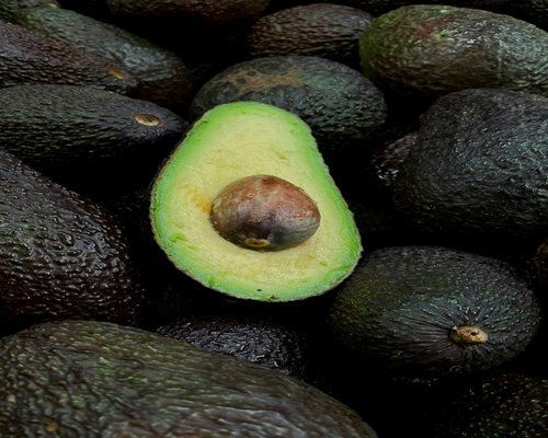 Halved fresh avocado showing the seed and green flesh